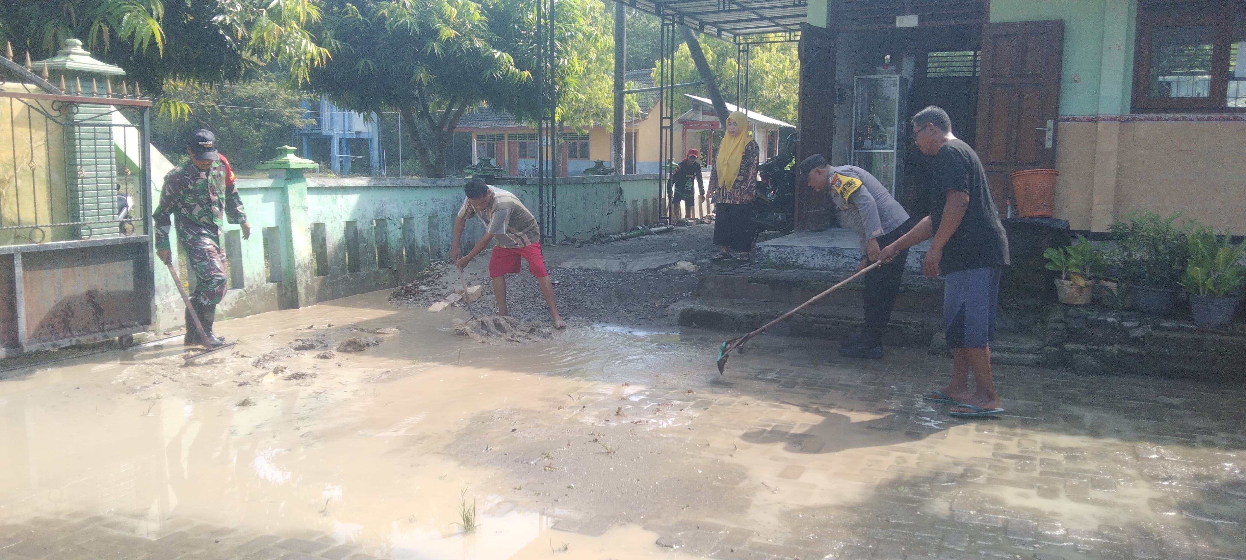 Gotong Royong Polisi dan TNI bersama Warga Bersihkan Sisa Meterial Banjir di Tuban